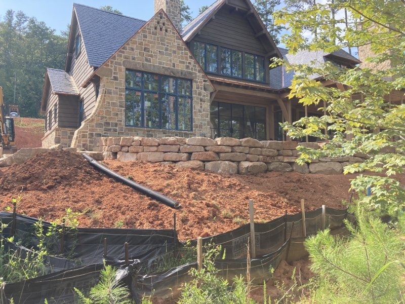 Backside-view-of-home-w-boulder-wall-in-process