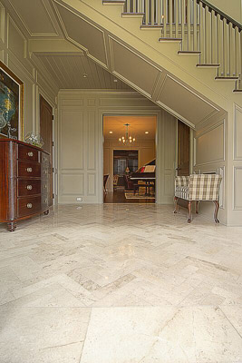 Herringbone pattern limestone floors, panelized walls and underside of stair